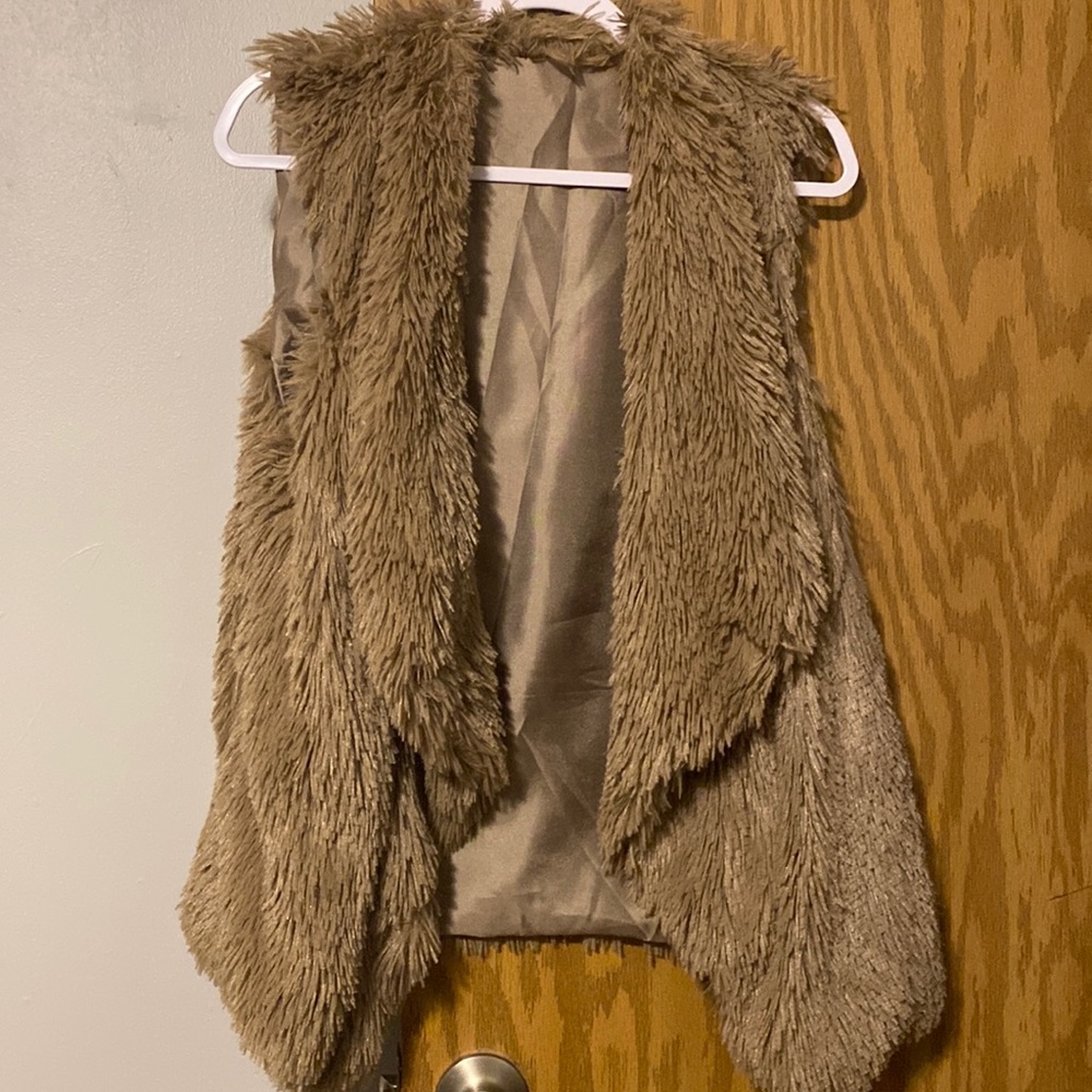Soft tan shaggy vest.  One size but I wear XL and it is fine.  Like new!